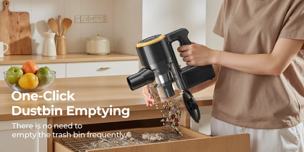 Person using a handheld lenoro v9 vacuum cleaner to empty a trash bin in a kitchen.