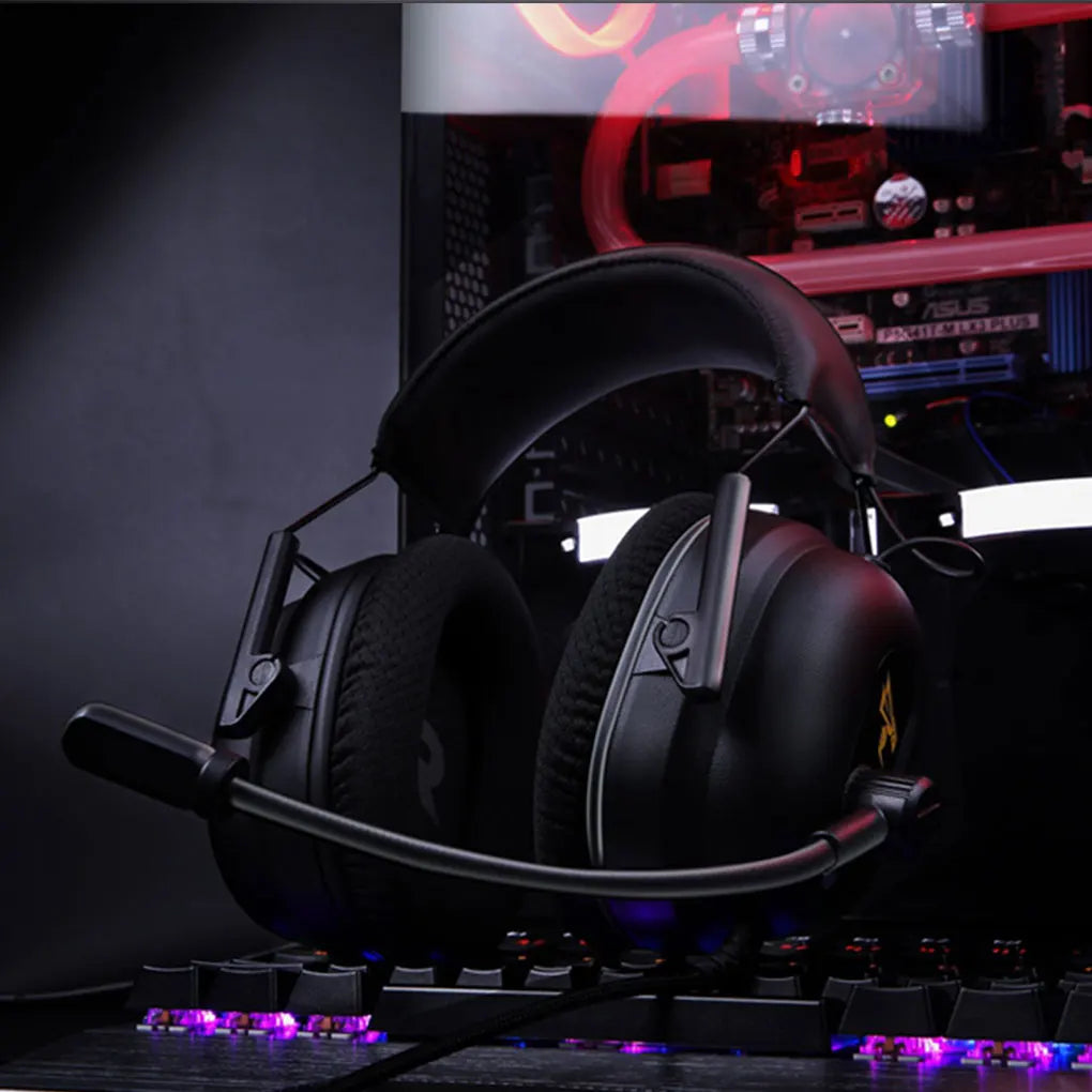 Commander G Series Gaming Headphones with microphone on a desk in front of a computer setup with RGB lighting.
