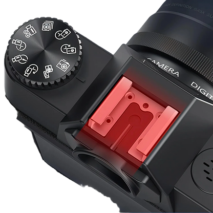 Korons Digital Camera body with a red flash attachment on a dark background