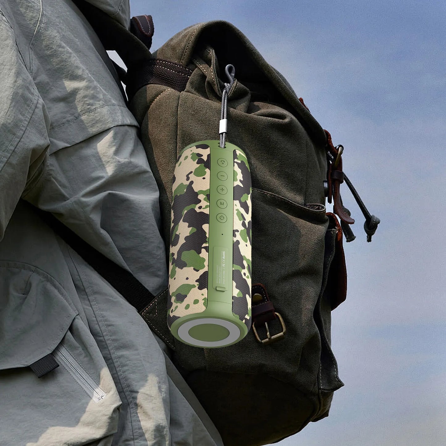 Camouflage-patterned Meacode Portable Bluetooth Speaker attached to a backpack with a clear sky background