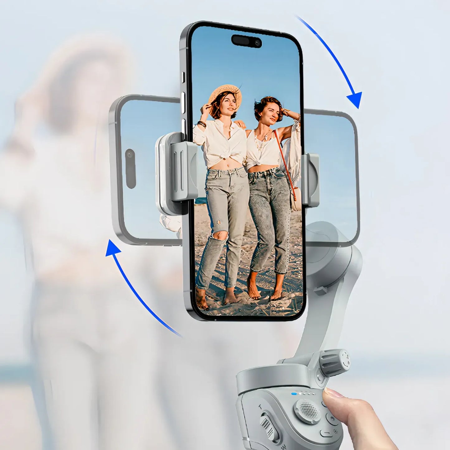 Hand holding a smartphone with a phone holder displaying two women on screen against a blurred background