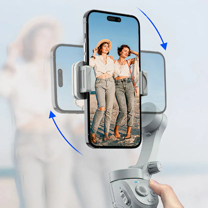 Hand holding a smartphone with a phone holder displaying two women on screen against a blurred background
