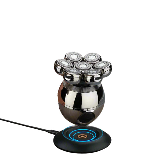 Hand holding a metallic device with multiple nozzles on a wooden surface.