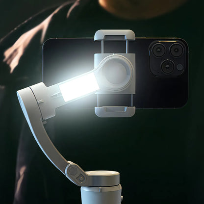 Smartphone with a mounted light and Puruxe Gimbal on a dark background