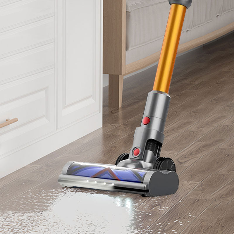 Stick drexen vacuum cleaner a wooden floor in a room with white walls and a bed.