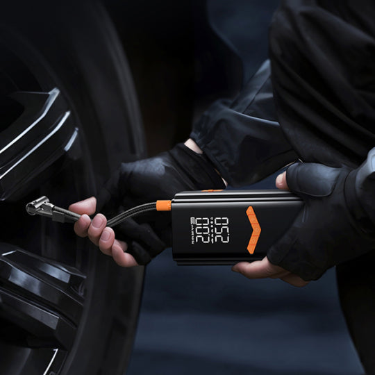 Person using a digital Moxier 2 in 1 Tyre Inflator Jump Starter on a car tire